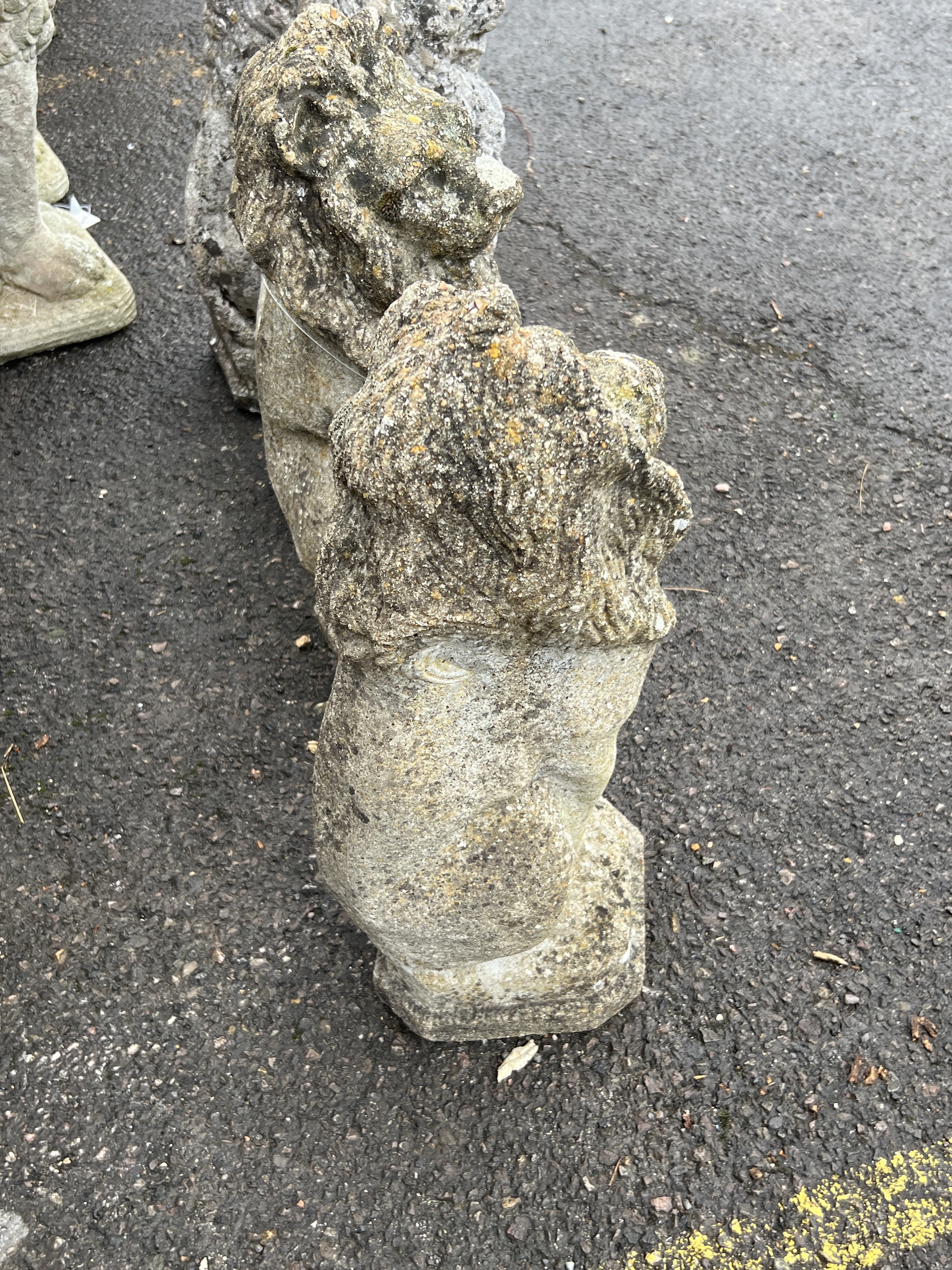 A pair of reconstituted stone seated lion garden ornaments, height 55cm
